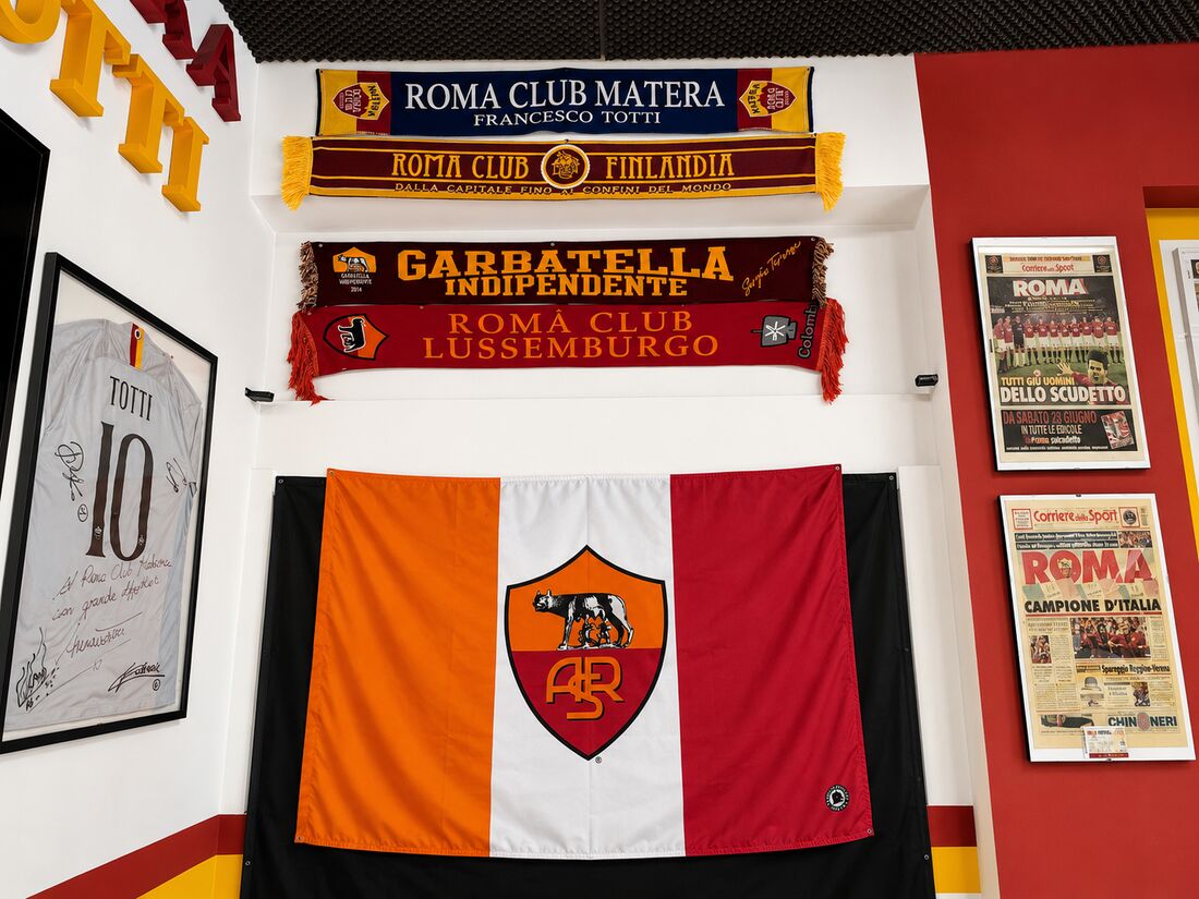 Sciarpe dei club gemellati e bandiera della Roma nella sede